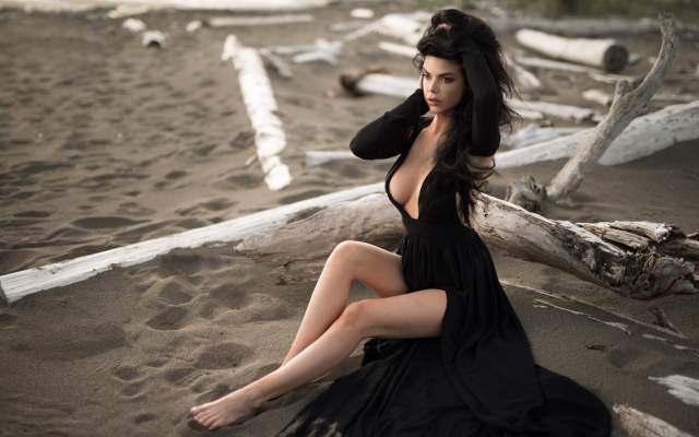 2048x1367 pix. Wallpaper sitting, black dress, cleavage, sand, looking away, beach, legs, boobs, brunette
