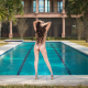 nude, back, ass, hands on head, swimming pool, high heels, palms, tropical, curly hairs wallpaper