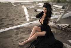 sitting, black dress, cleavage, sand, looking away, beach, legs, boobs, brunette wallpaper
